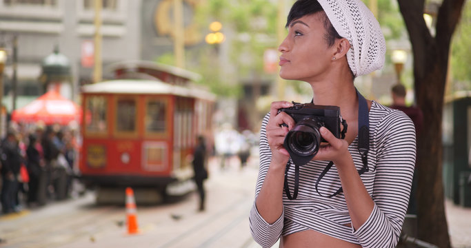 Woman with camera taking photo on San Francisco city street with