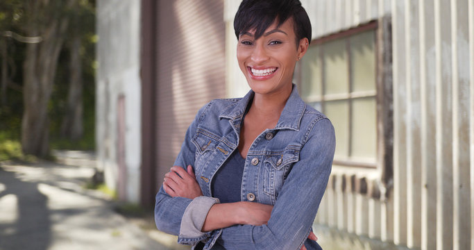 Confident millennial woman with arms crossed wearing jean jacket