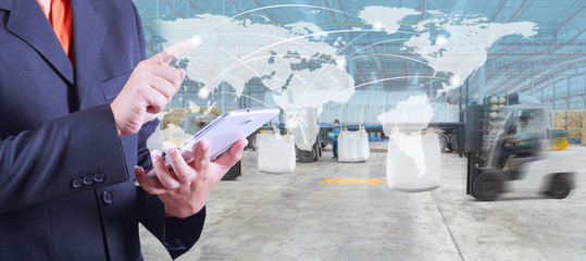 hand presses on world map with digital tablet,warehouse worker loading goods by forklift for...