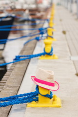 Straw hat in port with yacht in background, travel, summer time