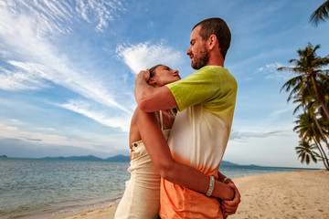 Young smiling couple embracing on a tropical beach
