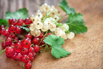 Obraz na płótnie Canvas ripe red currant on wooden background with copy space