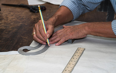 A tailor's work table with cloth for a jacket cut and marked up for sewing.
