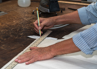 A tailor's work table with cloth for a jacket cut and marked up for sewing.
