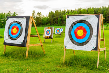 Outdoor archery targets on grass field surrounded by forest in the summer evening. - 114288916