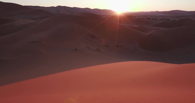 4K panning shot of sun rising over the sand dunes inside the Namib-Naukluft National Park