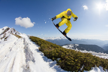 Snowboard rider jumping on mountains. Extreme snowboard freeride sport.