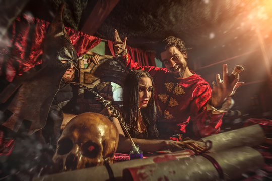 Medieval inquisitor is tempting witch to sign the confession, bu