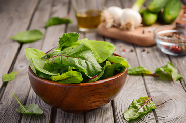 Fresh salad leaves in a wooden bowl on rustic background, selective focus