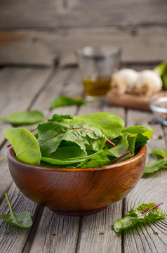 Fresh salad leaves in a wooden bowl on rustic background, selective focus, copy space