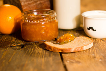 Opened jar with grapefruit jam and crispy bread