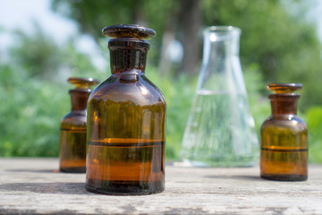 Liquid in chemical ware on a background of plants, fertilizers or pesticides in the garden.