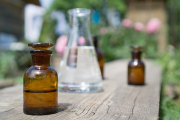 Liquid in chemical ware on a background of plants, fertilizers or pesticides in the garden.