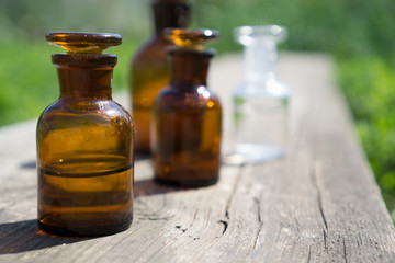 little brown bottles on wooden board and green grass