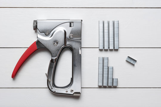 Large tacker stapler gun with clips on wooden floor