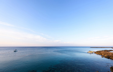Fototapeta premium Photo of sea in protaras with rocks, cyprus island with boats at sunset.