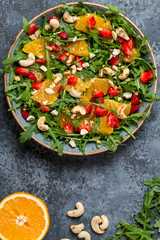 Fresh salad with arugula, fruits and nuts.