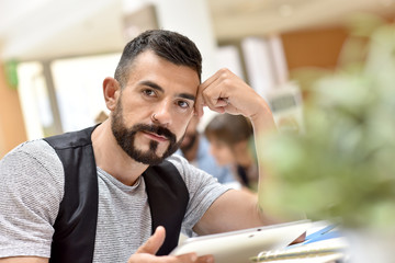 Trendy businessman in office working on tablet