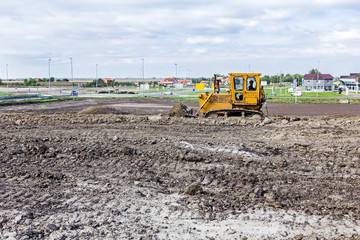 Obraz premium Bulldozer machine is leveling construction site