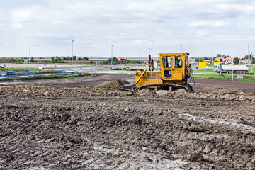 Bulldozer machine is leveling construction site