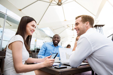 Positive smiling colleagues sitting at the table