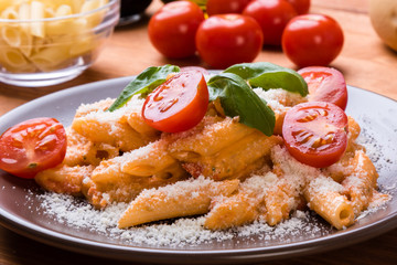 penne with tomato in brown plate