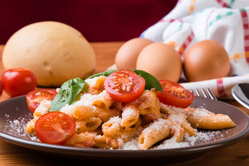 penne with tomato in brown plate