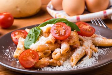 penne with tomato in brown plate