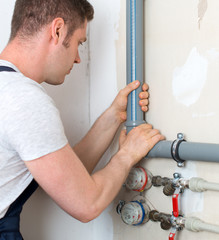 Male plumber assembling water pipes.