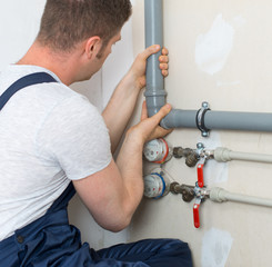 Male plumber assembling water pipes.
