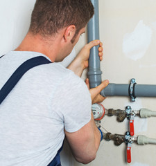 Male plumber assembling water pipes.