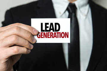 Business man holding a card with the text: Lead Generation