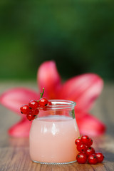 jar with pink grapefruit cocktail on green background bokeh