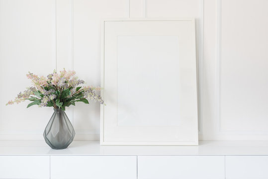 glass vase of flower with white picture frame