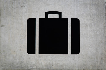 Suitcase sign at airport baggage claim on concrete wall