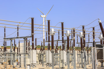 Detail of electrical substation of a wind farm, with a wind turbine at background