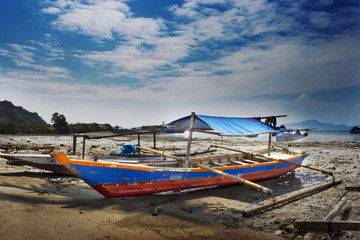 Naklejka na ściany i meble fishing boat on the beach at low tide