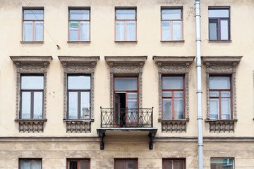 Fototapeta na wymiar Facade of classic house with windows and a balcony.