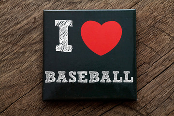 I Love Baseball written on black note with wood background