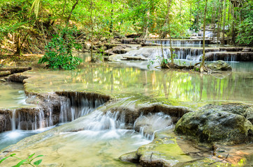 Obraz premium Beautiful waterfall and tropical forests at Erawan National Park is a famous tourist attraction in Kanchanaburi Province, Thailand