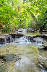 Fototapeta na wymiar Erawan Beautiful waterfall and tropical forests at Erawan National Park is a famous tourist attraction in Kanchanaburi Province, Thailand in Thailand