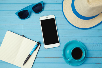 Summer holiday background with smartphone and notebook. Vacation planning concept. View from above