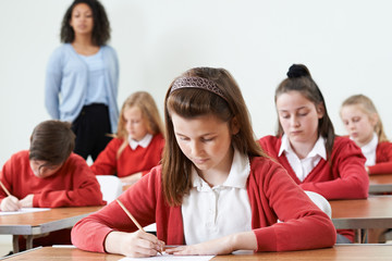 Female Pupil At Desk Taking School Exam