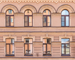 Several windows in a row on facade of urban apartment building front view, St. Petersburg, Russia.