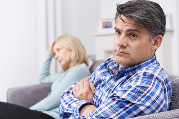 Couple With Relationship Difficulties Sitting On Sofa
