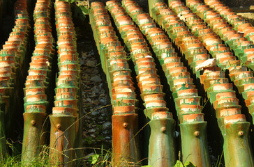 Stacks of old orange weathered roof shingles. Green glazed ceram