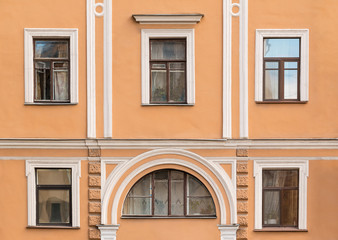 Several windows in a row on facade of urban apartment building front view, St. Petersburg, Russia.