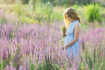 Fototapeta na wymiar girl in a field of purple salvia 