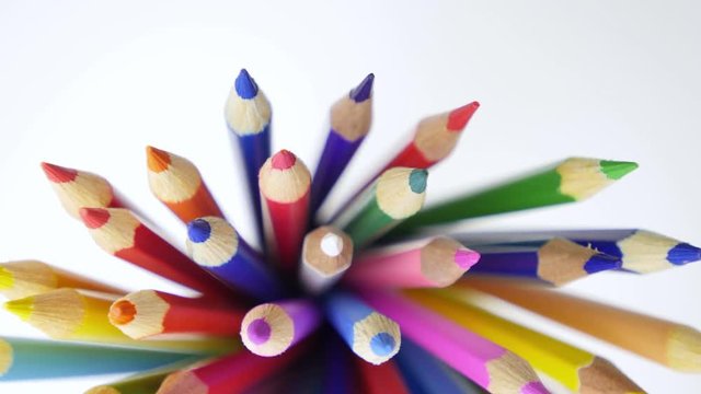 Color pencils turning on a white background. Close up. 