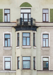 Several windows in a row and bay window on facade of urban apartment building front view, St. Petersburg, Russia.